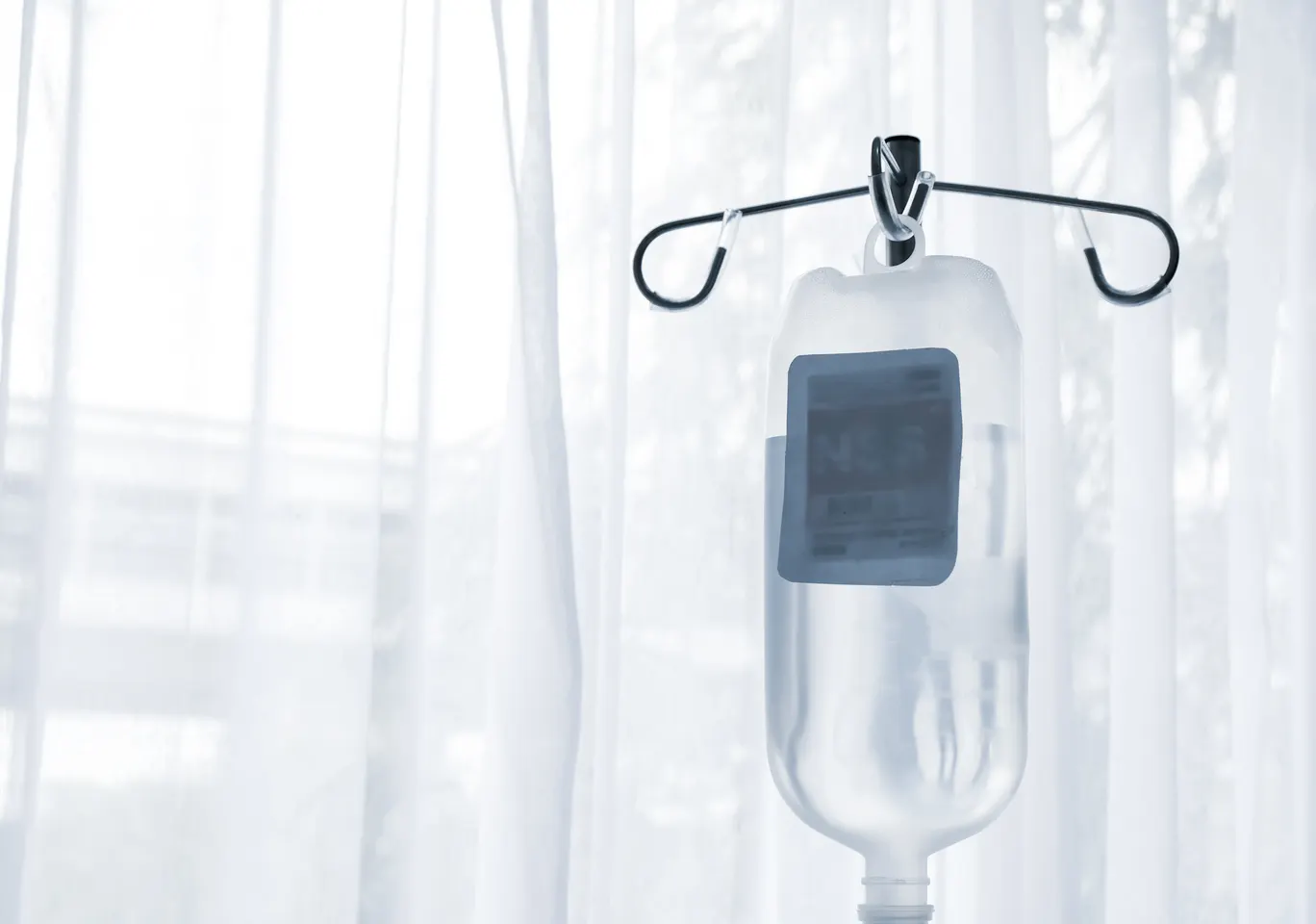 Kroplówki witaminowe Mława: butelka płynu infuzyjnego zawieszona przy oknie