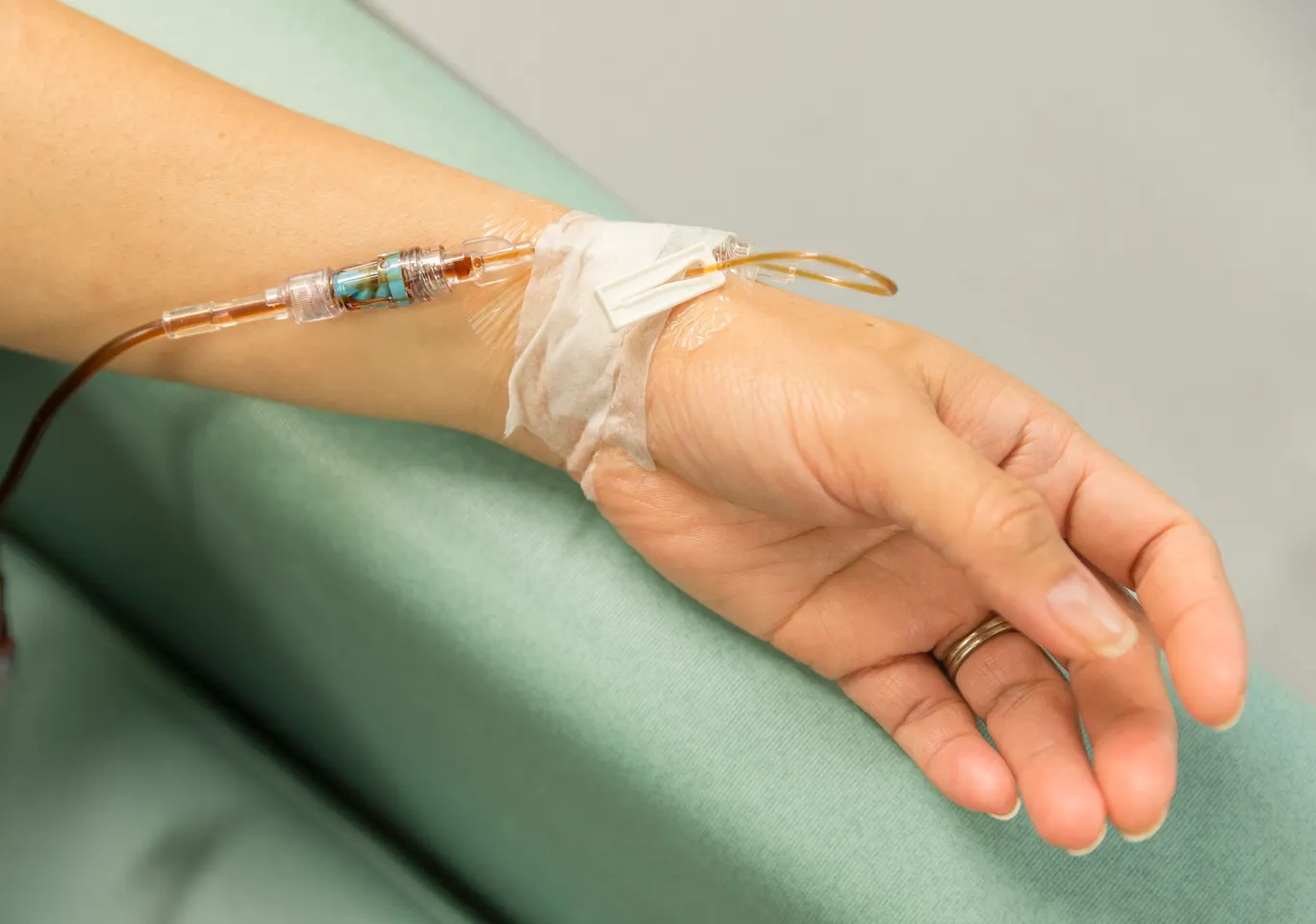 Kroplówki witaminowe Ciechanów: dłoń z wenflonem i linią infuzyjną na podkładzie